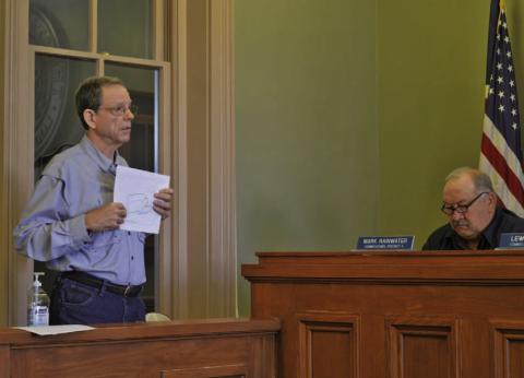 ERICK MITCHELL | DISPATCH RECORD Area resident Mike Watson, who owns property near the proposed Pitt Creek Ranch development, gives an update at Monday’s Commissioners Court meeting on the Lampasas County Municipal Utilities District #1 application that awaits approval from the Texas Commission on Environmental Quality. Also pictured, at right, is Precinct 4 Commissioner Mark Rainwater.