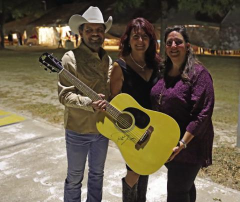 Boots and Blazers Ball benefits local art scene Texas country music artist Rick Trevino presents a signed guitar to LAFTA board members Debbie Reynolds, center, and Catherine Kuehne for auction at the Boots and Blazers Ball on Saturday evening. Proceeds of the auction benefited the Lampasas Association for the Arts. MICHAEL KUEHNE | K DIGITAL PRO