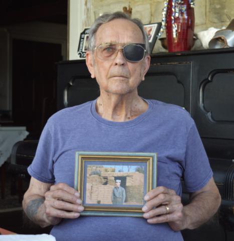 Marine Corps veteran James Welch displays a photo of himself from his younger years in the service outside a bunker. ERICK MITCHELL | DISPATCH RECORD