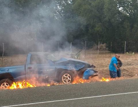 Brandon Roedler helps get a man to safety after he was trapped in a burning vehicle Sunday morning just outside of Burnet on Hoover Valley Road. COURTESY PHOTO
