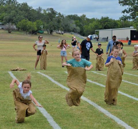 Children try their best to maintain balance during sack races at Kids’ Day Activities hosted by the Lampasas Boys and Girls Club. ERICK MITCHELL | DISPATCH RECORD