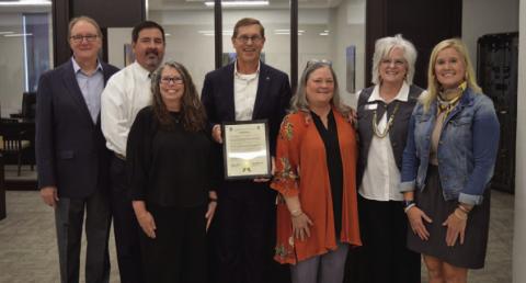 First Texas Bank of Lampasas officers, left to right, Barry Haag , Lee Loeffler, Pam Hunter, Kelvin Barkowsky, Donna Roberts, Ladonna Bishop and Annie Trotter pose with a resolution plaque celebrating 140 years of business in Lampasas. ERICK MITCHELL | DISPATCH RECORD