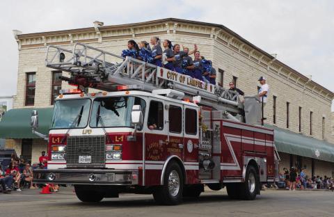 Lampasas High School cheerleaders wave to the crowd atop a Lampasas Fire Department engine during Saturday’s 53rd annual Spring Ho Grand Parade. ADAM BARRIOS | DISPATCH RECORD