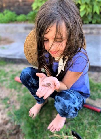 Cecily Hatley, age 8, sets an example of wonder and enjoyment as she examines and appreciates an earthworm found in her mother’s flower garden. Joycesarah McCabe | Dispatch Record
