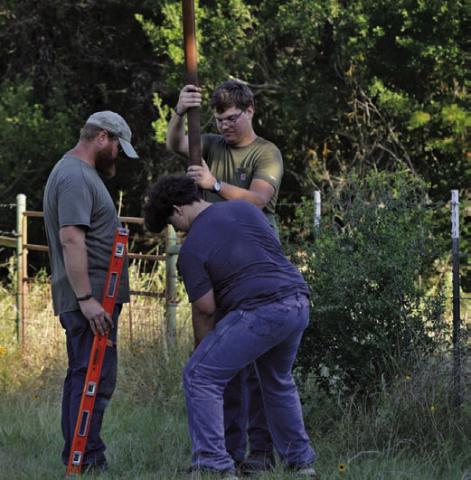 Brennen Barber helps install a 32-foot pole into the ground at Kempner’s Sylvia Tucker Memorial Park on Friday morning. Barber installed two poles for his bat-box project, with each pole able to hold two boxes. ERICK MITCHELL | DISPATCH RECORD