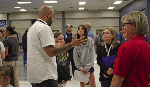 Lola Patterson and her mother, Maurine Patterson, learn about the culinary arts program from teacher Jason Walsh during Ninth-grade Preview Night last week at the high school. VERONICA BUTLER | DISPATCH RECORD