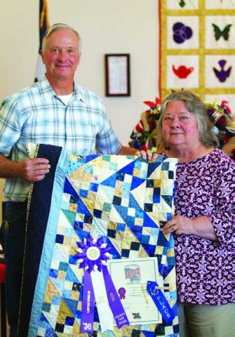 Connie Hamill was named the overall grand champion of the County Fair with this quilt. County Judge Randy Howyer is photographed with her. HUNTER KING | DISPATCH RECORD