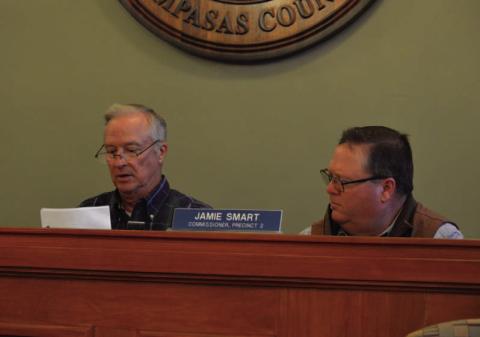 At left, County Judge Randy Hoyer unseals proposed bids for courthouse renovations as Precinct 2 Commissioner Jamie Smart looks on. ERICK MITCHELL | DISPATCH RECORD
