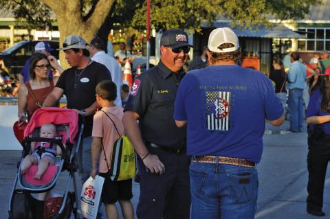 Lampasas Fire Chief Tim Davis, right, speaks with Lampasas High School EMT teacher Steve Haviland during last year’s event. Plenty of local and state law enforcment agencies will be at Tuesday’s National Night out event in the Lampasas H-E-B parking lot. FILE PHOTO