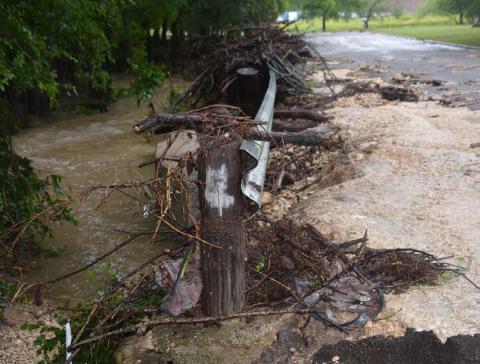 A bridge on East Avenue H sustained damage during Saturday morning’s heavy rains that pummeled the northeast portion of the city. In addition to debris strewn about the guardrail, pavement on the bridge shows significant damage. Water in the creek remained high. JIM LOWE | DISPATCH RECORD