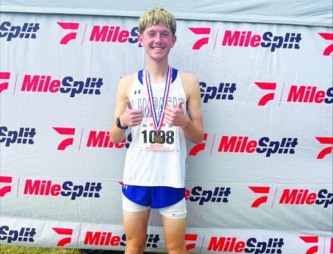 COURTESY PHOTO | KIM BURNSIDE John Keyes poses with his medal after finishing 10th at the regional cross country meet and qualifying for state.