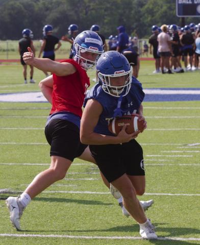 Ross Kothmann, left, makes a handoff to Luke Lambert on Tuesday afternoon, the second day of football practice at Lampasas High School.ERICK MITCHELL | DISPATCH RECORD