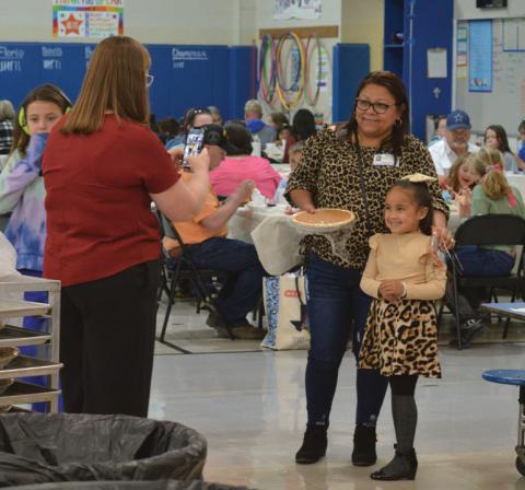 Hanna Springs Elementary School counselor Carisa Brown snaps a photo of Sandra Ceballos and Victoria Garza. Ceballos received a pumpkin pie for making the long trip from Piedras Negras, Mexico, for Thursday’s Grandparents’ Day at the campus. erick Mitchell | dispatch record