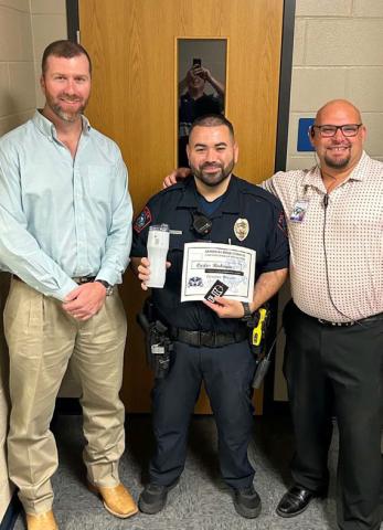courtesy photo Named the Star Supporter of the Month is Carlos Rodriguez, center, who serves as the high school’s school resource officer. On hand to congratulate him are Clay Phillips, left, of Texas Farm Bureau Insurance and Assistant Principal Ryan Race. “Rodriguez has done a phenomenal job, often going above and beyond his required duties,” said Race.