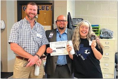COURTESY PHOTO Clay Phillips of Texas Farm Bureau Insurance, at left, joins Lampasas High School Assistant Principal Ryan Race in congratulating Rebecca Veroneau on her selection as the campus’ Teacher of the Month for August. “She is a problem-solver with a heart of gold, and we are blessed to have her,” Race said of the Life Academics teacher.