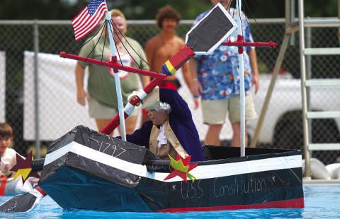 Case Jones rows the U.S.S Constitution across the Hanna Springs Swimming Pool during the Cardboard Regatta event on Saturday. HUNTER KING | DISPATCH RECORD