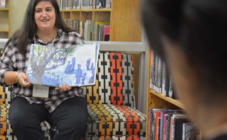 Assistant Librarian Emily Stone reads “This Very Tree” by Sean Rubin, while Library Clerk Sammi McKenzie livestreams on her phone during the weekly storytime Wednesday morning at the Lampasas Public Library. MONIQUE BRAND | DISPATCH RECORD
