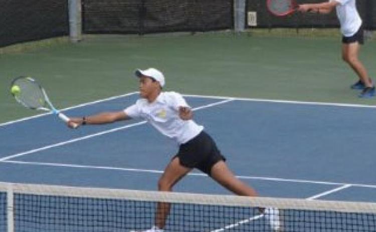 Mario Aguirre hits the ball near the net while Sam Zmolik plays the baseline in the boys’ doubles quarterfinals match at regionals. KENNETH PEISER | COURTESY PHOTO