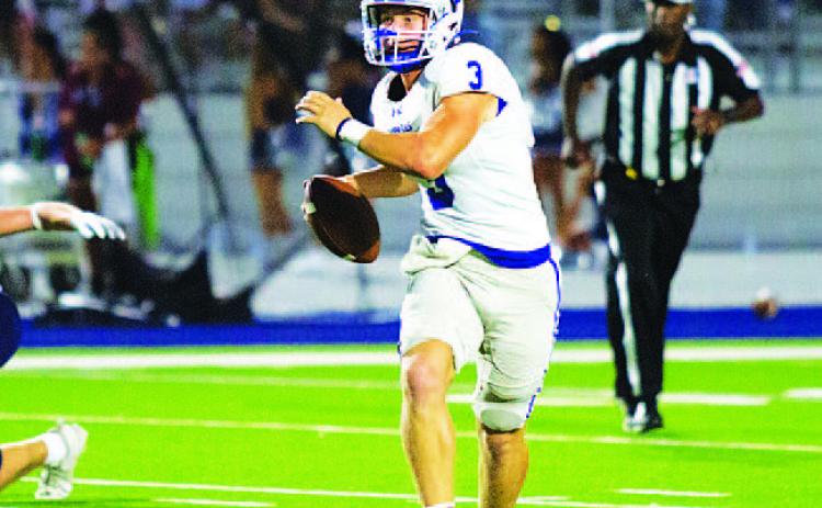 Reed Jerome rolls to his left and looks for a receiver during last Friday’s game. HUNTER KING | DISPATCH RECORD