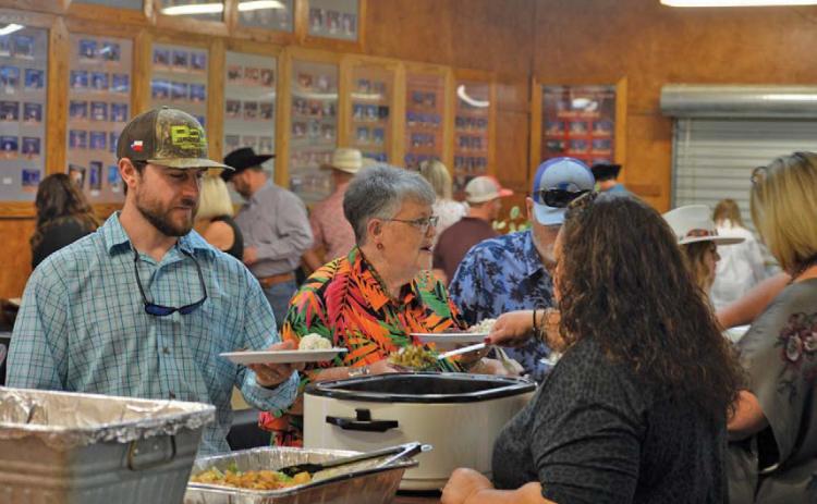 Lampasas County Livestock Association Reverse Raffle attendees stand in line to receive their food during Saturday’s event festivities. erick mitchell | dispatch record