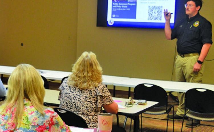 TDEM Regional Recovery Coordinator Matthew Weeks provides a presentation to the Lampasas County Commissioners Court and representatives of other local entities to outline the availability of FEMA public assistance to cover May’s flooding events. ERICK MITCHELL | DISPATCH RECORD