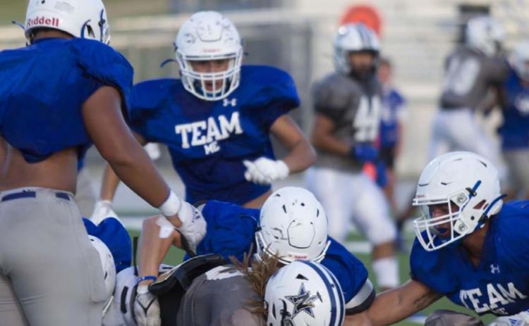 A group of Badgers is in on the tackle of a Navasota ball carrier during the live quarter of the scrimmage. HUNTER KING | DISPATCH RECORD