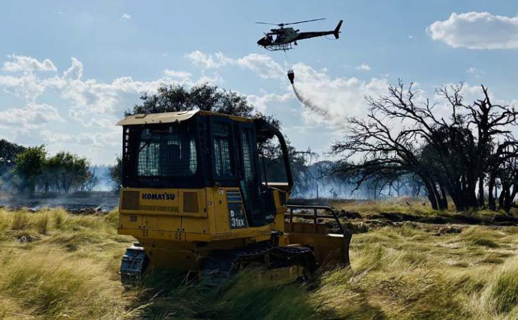Wildfires arise unexpectedly, but having firebreaks on the land and a plan for cattle relocation are part of ranch preparedness when an emergency strikes. This photo shows a water drop during the Herring fire that occurred Aug. 11. Assistance from local emergency responders and the Texas Forest Service helped limit damage on the ranch. file photo