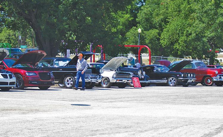 Residents walk along the park road and check out different kinds of vehicles during Saturday’s Sulphur Creek Car Cruise in W.M. Brook Park. hunter king | dispatch record