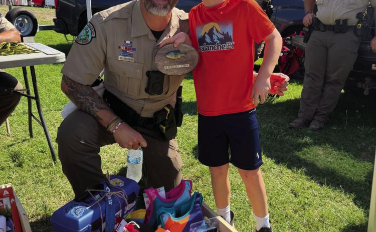 Brian Watson (left) sheds a smile after catching the smallest fish at doLampasas’ Fishes and Loaves Festival on Sunday. Lampasas County Game Warden Ray Milloway joined in to congratulate him.
