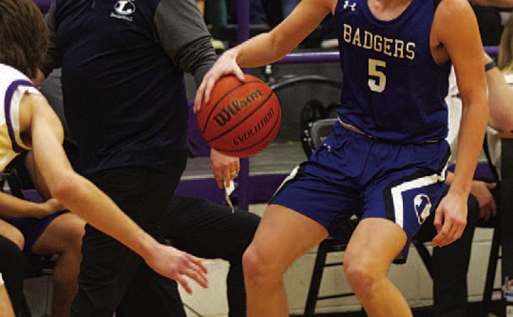 HUNTER KING | DISPATCH RECORD Trent Seneca dribbles down the court as head coach Aaron Nuckles looks on.