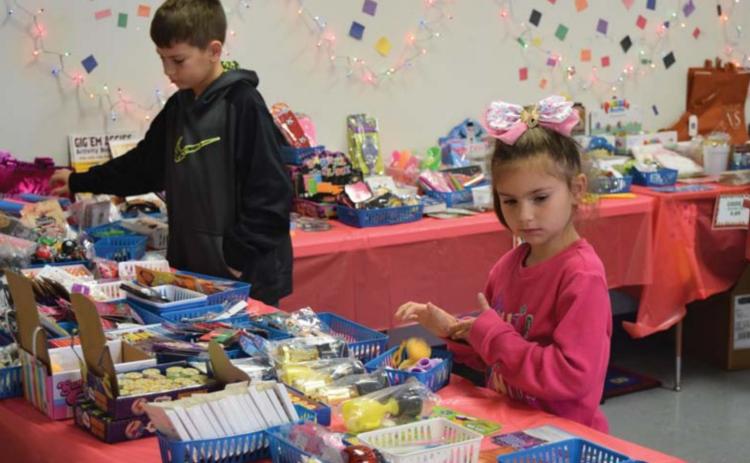 Fourth-grader Brenton Withers and first-grader Mya Rodriguez shop at the Peppermint Village Gift Shop at Hanna Springs Elementary on Tuesday. ALEXANDRIA RANDOLPH | DISPATCH RECORD