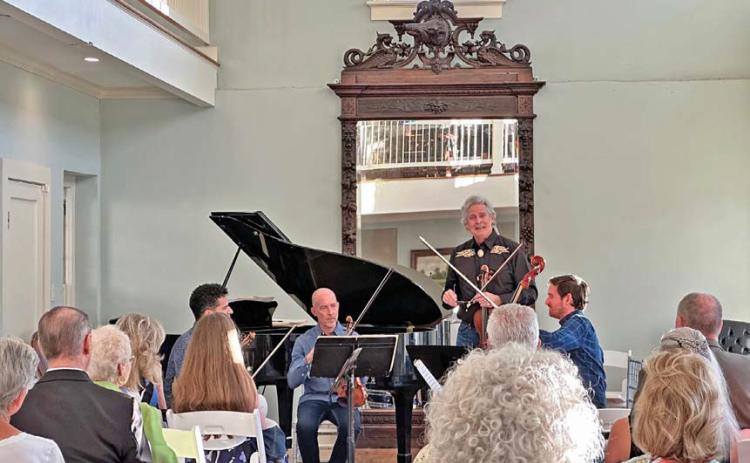 Bruce Williams introduces fellow musicians Patrice Calixte, Douglas Harvey and Dr. Stephen Redfield as they prepare to perform “Quartets at the Keystone” for the audience at the Keystone Star Hotel ballroom during last year’s Lampasas Chamber Music Festival in June. file photo