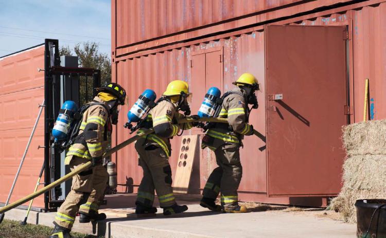 ADAM BARRIOS | DISPATCH RECORD Firefighters practice hose advancement and fire suppression as they enter the training building behind the Lampasas Fire Station. The all-day Saturday session offered a controlled environment in which firefighters from across Lampasas County could collaborate and hone their skills to be better prepared for emergencies that might arise.