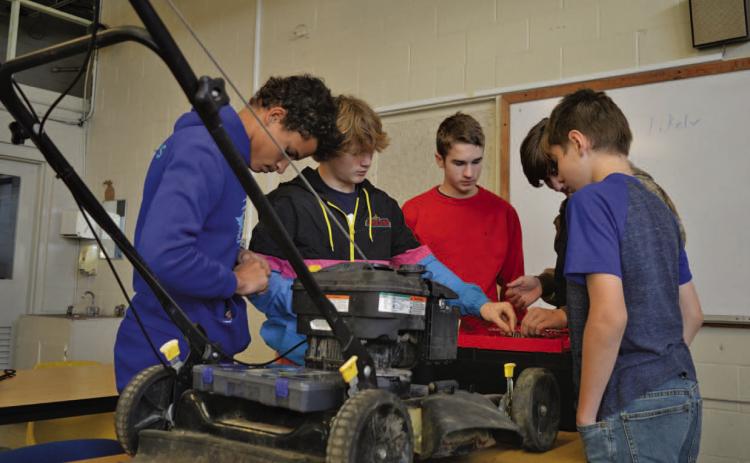 Lampasas Middle School students work on running diagnostics with a lawnmower Friday morning during their small-engines class. ERICK MITCHELL | DISPATCH RECORD