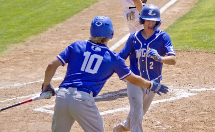 District MVP Ace Whitehead high-fives first-team all-district infielder Eli Stanley after Stanley scored a run in the playoffs.