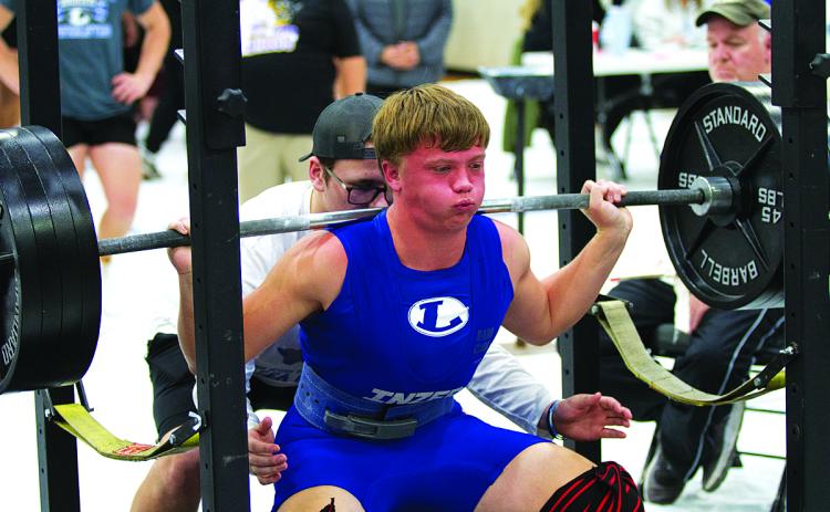 Carter Kuhn squats during the recent home powerlifting meet.