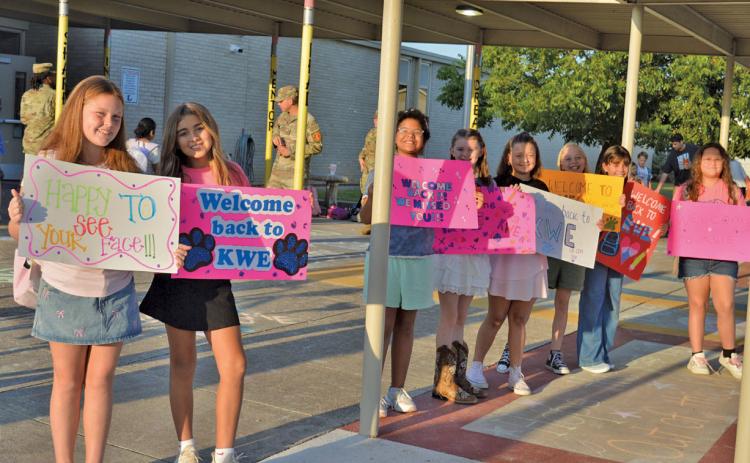 Kline Whitis students, from left, Jentry Jones, Christianna Gonzalez, Nikita Olsen, Kylee Davis, Hazel Cecil, Nadia Martin, Brooklyn Alderson, and Autumn Hiller welcome classmates on the first day of school. erick mitchell | dispatch record