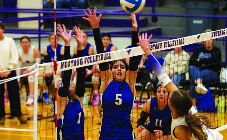 Ysa Swain (5) and Brailey Wilson (1) leap for a block during the Lady Badgers’ match against Marble Falls on Tuesday. HUNTER KING | DISPATCH RECORD