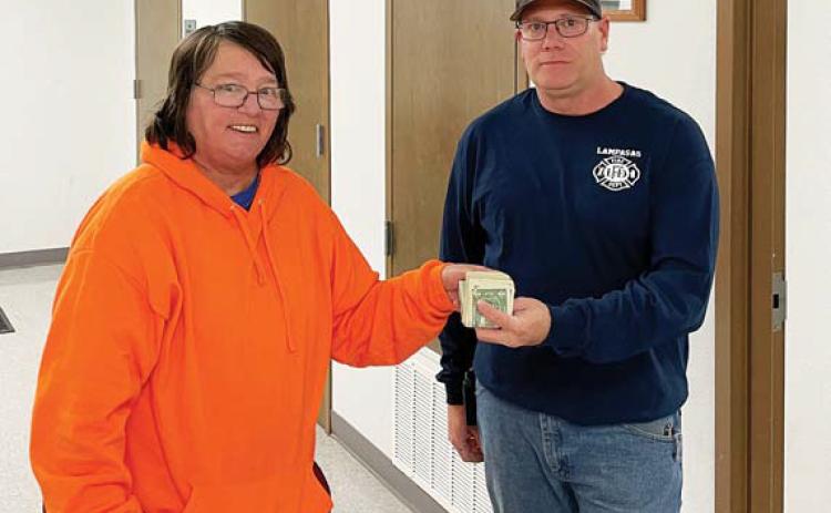 Darlene Cockrell Johnson presents $922 to Lampasas Volunteer Fire Department representative Tim Weinrick. The money, which is to be used to provide toys at Christmas for area children, represents donations collected at two recent fundraisers: an enchilada dinner hosted at the fire station with help from the ladies at Community Kitchen, and a bowling tournament held at Putters &amp; Gutters Fun Center. Johnson thanked the community for its generous donations, auction items and support. courtesy photo