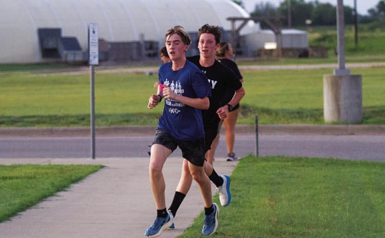 Parker Boykin, front, and Gabriel Allison round the corner during the Monday morning run. HUNTER KING | DISPATCH RECORD