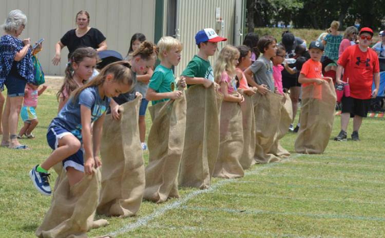 hunter king | LAMPASAS DISPATCH RECORD Children climb into their potato sacks before the command to begin during Spring Ho Kids’ Day activities on Friday.