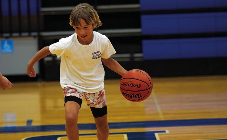 Kaylor Chapa dribbles as the kids compete in a game at the end of the first day of camp. HUNTER KING | DISPATCH RECORD