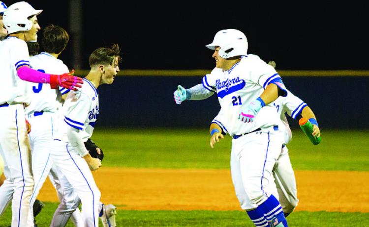 Benny Rodriguez (21) celebrates with his teammates after knocking in the winning run. HUNTER KING | DISPATCH RECORD