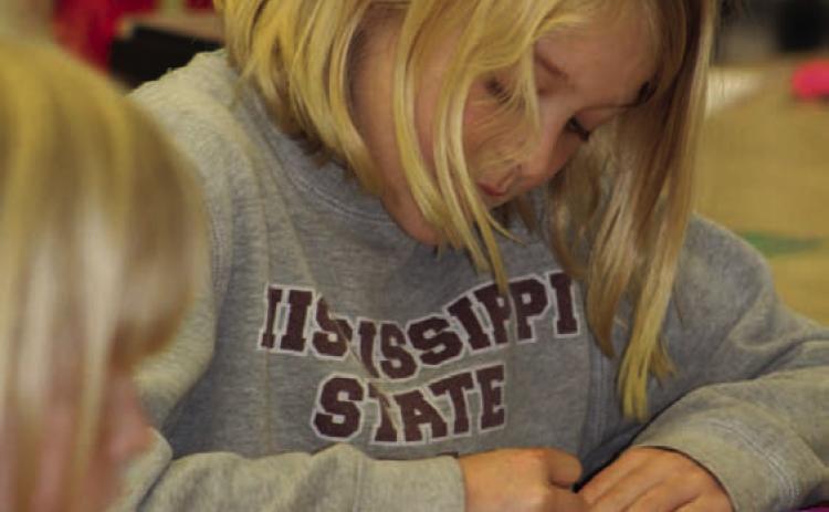 Hadley Crawford is busy preparing her strips of “protein” that will make a model of a double-helix DNA strand. The library hosted a STEAM event on “Heart and Lungs: Working Together.” JOYCESARAH MCCABE | DISPATCH RECORD