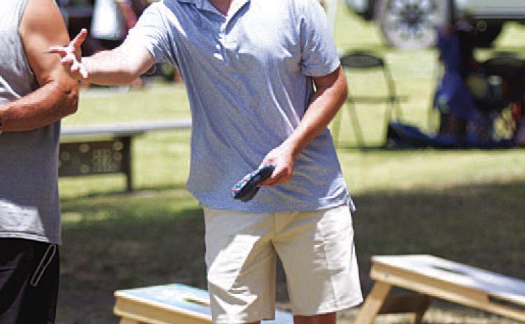 HUNTER KING | DISPATCH RECORD Nate Borchardt tosses a beanbag during the cornhole tournament.