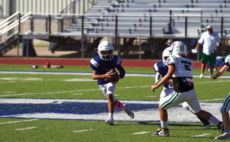 Kaylor Chapa rolls to his right during a BBYL game. HUNTER KING | DISPATCH RECORD