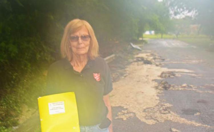 Dorothy Person, a local Salvation Army volunteer, pauses for a photo in front of the flood damages on Avenue H last month. COURTESY PHOTO