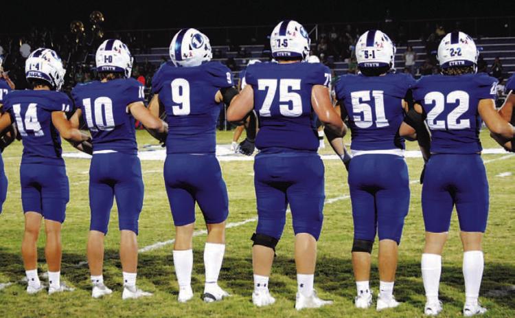 The Badgers stand locked arm in arm during the coin toss before every game. HUNTER KING | DISPATCH RECORD