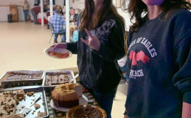Ashlynn Adams, at left, and Lyla Skiles serve food at a veterans dinner offered in partnership with Community Kitchen. courtesy photo