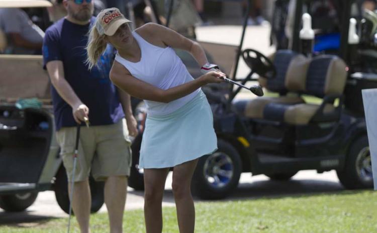 Carmen Gonzalez follows through on a shot during the chipping contest on Saturday. HUNTER KING | DISPATCH RECORD